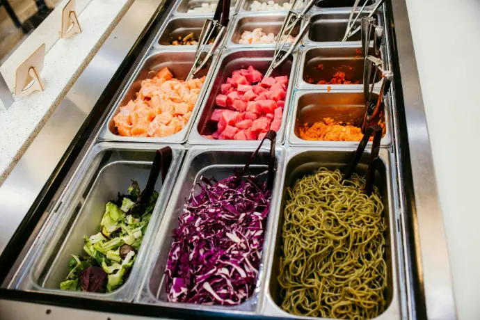 A salad bar with a variety of salads in trays